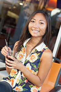 亚裔女孩在阳台上喝酒背景图片