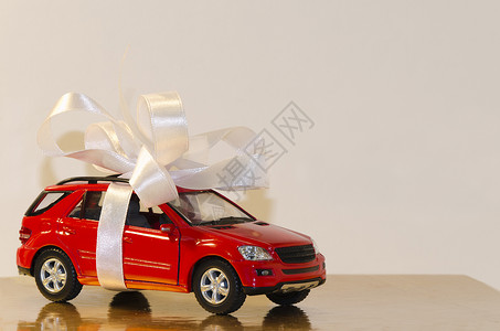红色车 带白丝带磁带桌子宏观礼物白色玩具背景图片