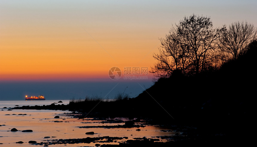 日落蓝色海洋血管海浪地平线戏剧性橙子岩石导航海岸图片