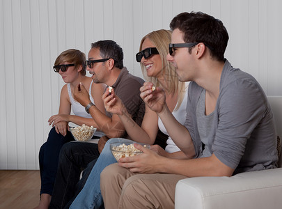 家庭观看3D电视电影女士休息室女儿父亲男性娱乐房间父母男人母亲高清图片素材