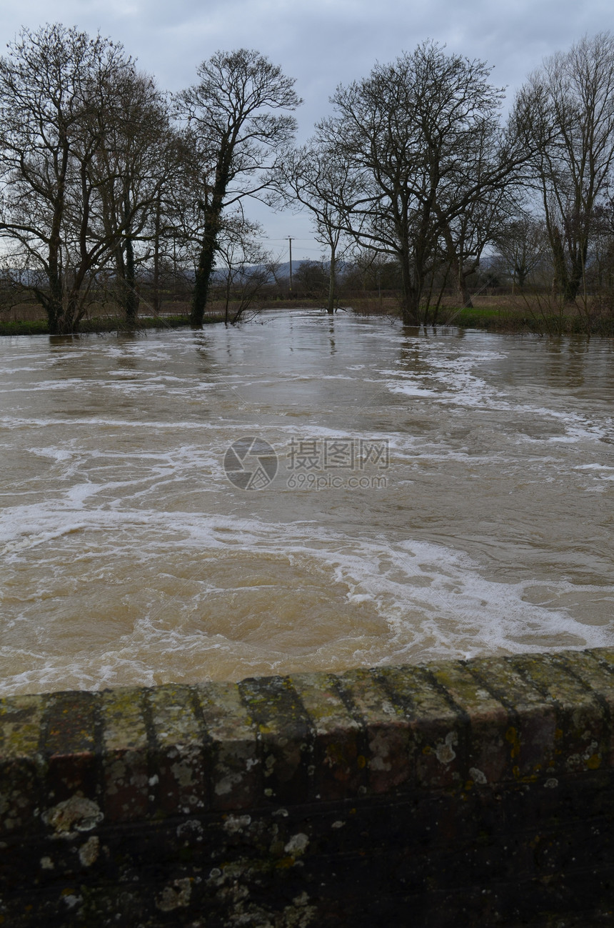 河水喷发着它的河岸银行天气风暴保险危险树木条形图片