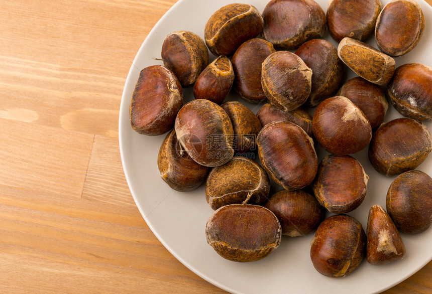 栗子在盘子里棕色桌子木头食物团体收成饮食坚果白色种子图片