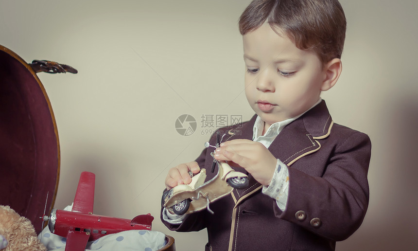 男孩玩锡玩具的虚拟肖像童年摩托车古董喜悦怀旧眼镜飞机孩子游戏乡愁图片