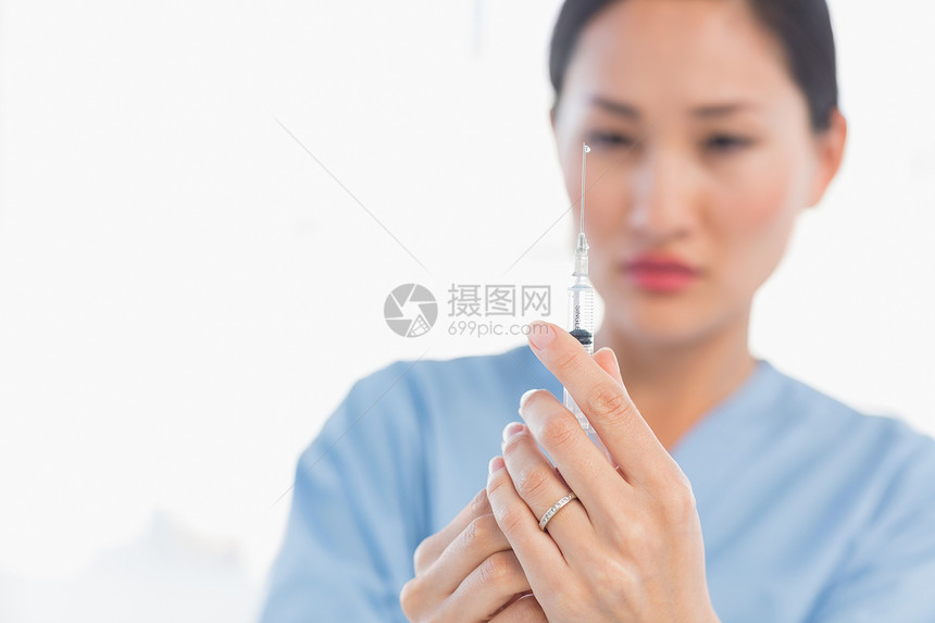 接受注射的重症女医生专注蓝色头发医务室外科女士棕色疫苗磨砂膏疾病图片