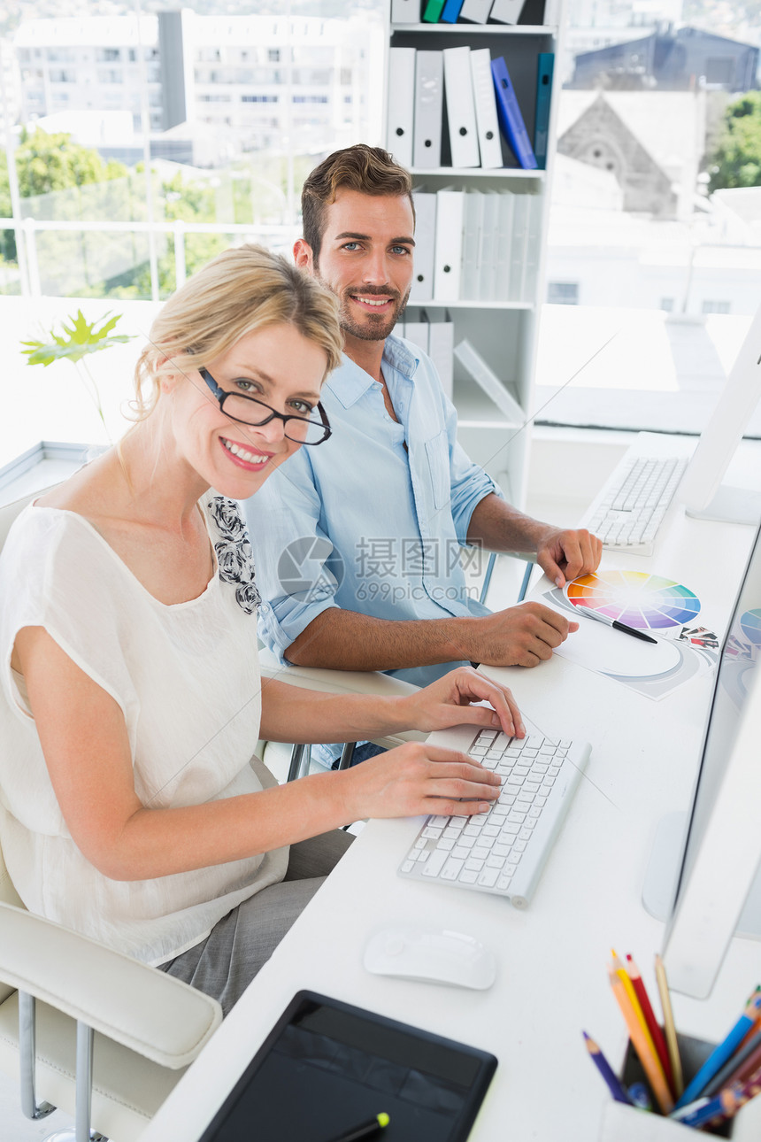 从事计算机工作的微笑的零散年轻夫妇办公室创造力同事键盘团队男性艺术家职业技术女士图片