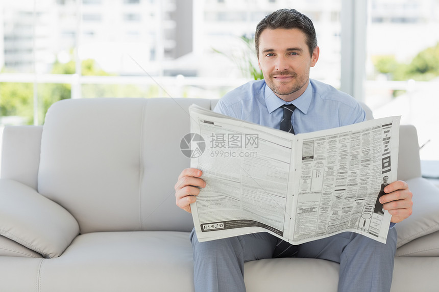 一名身穿穿着良好男子阅读报纸的肖像图片