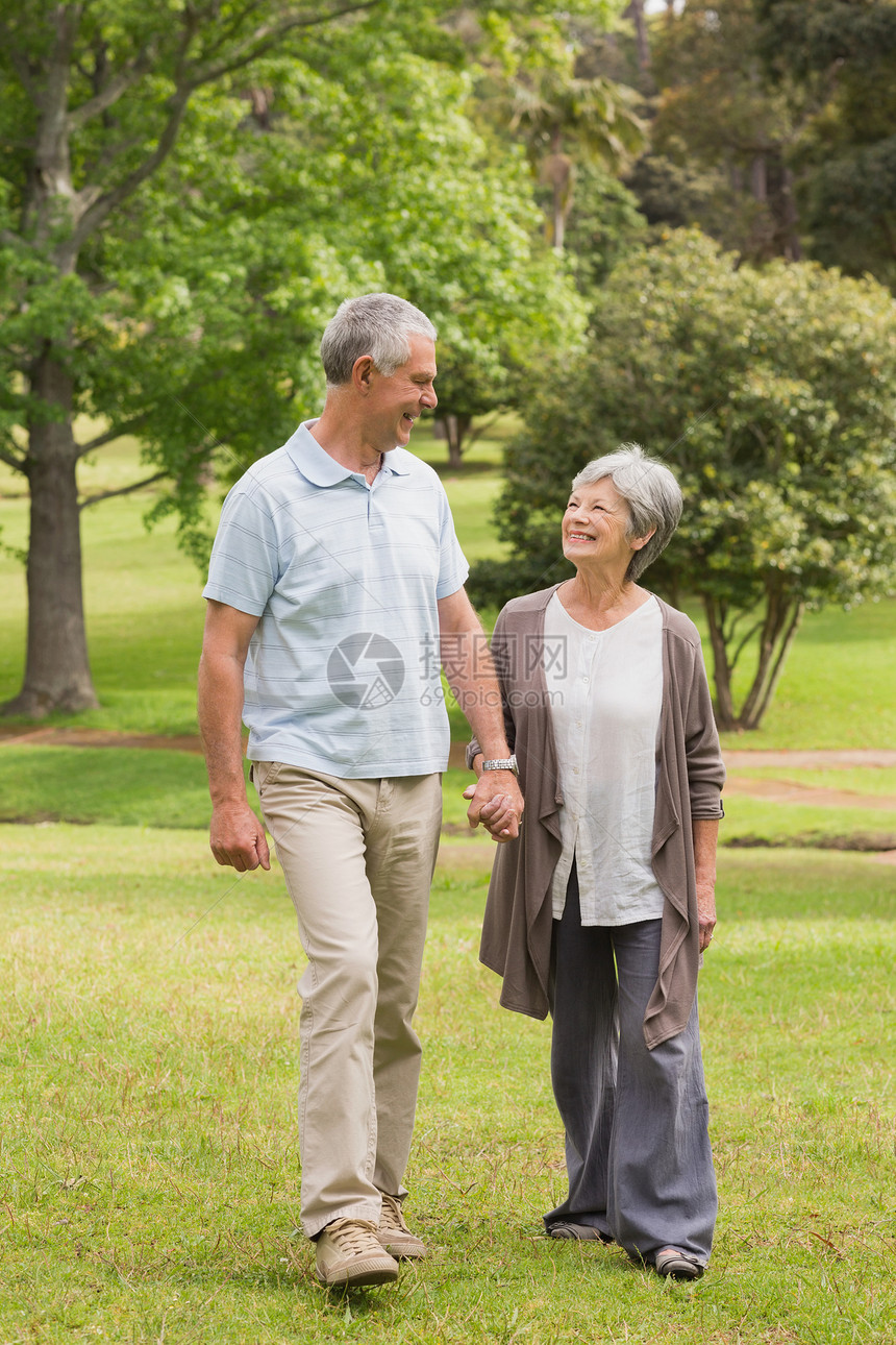 快乐的情侣手牵手在公园散步退休女士女性享受夫妻男人闲暇成人男性感情图片