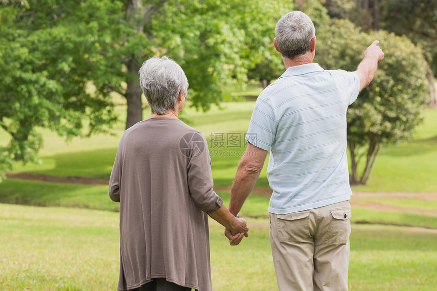 一对在公园握手的老年夫妇的近视图片