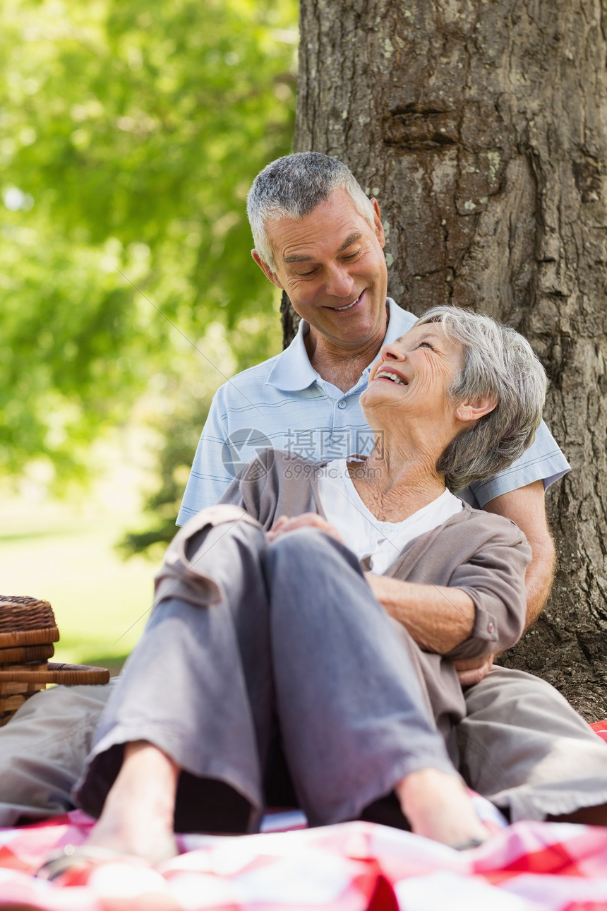 快乐放松的老年夫妇坐在公园里图片