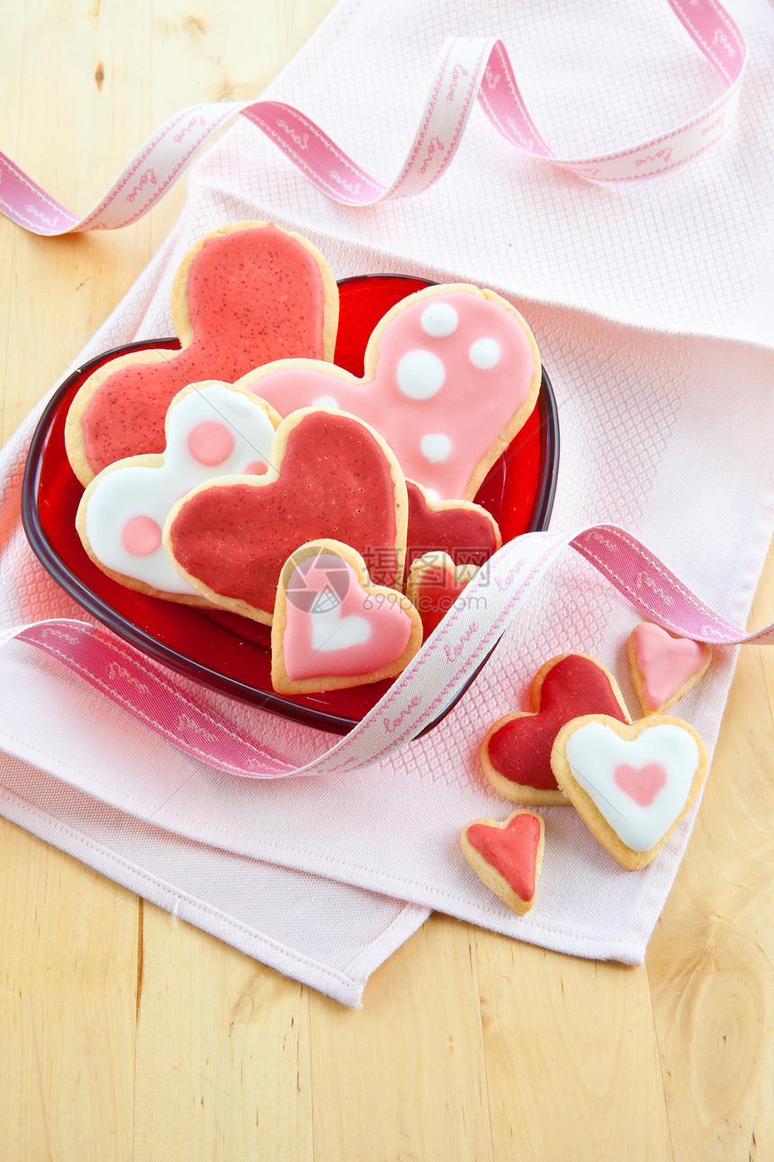 红色盘子上的多彩饼干恋爱糖果丝带展示焙烤装饰餐巾粉色心形乐趣图片