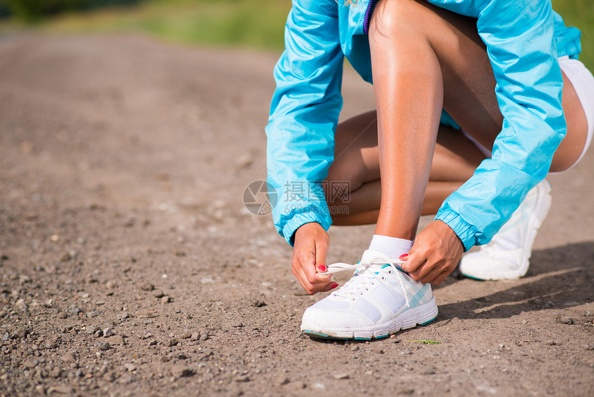 年轻女子在运动鞋上系鞋带力量女孩行动成人跑步宠物赛跑者身体锻炼女性图片