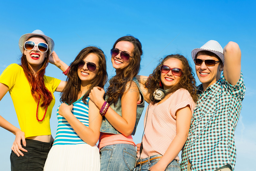 身戴太阳眼镜和帽子的青年群体乐趣男性阳光照射庆典闲暇男生太阳日落女孩享受图片