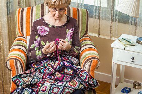 羊毛被子女人的肖像 编织古典羊毛手工祖母床罩毛衣工艺手指针线活老年母亲被子背景