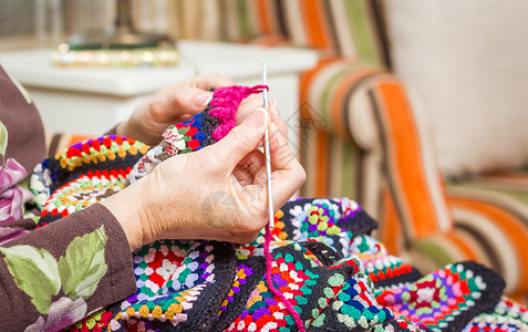 羊毛被子女人的手编织着古典羊毛毛衣针线活钩针女性成人纺织品手工手指退休工作背景