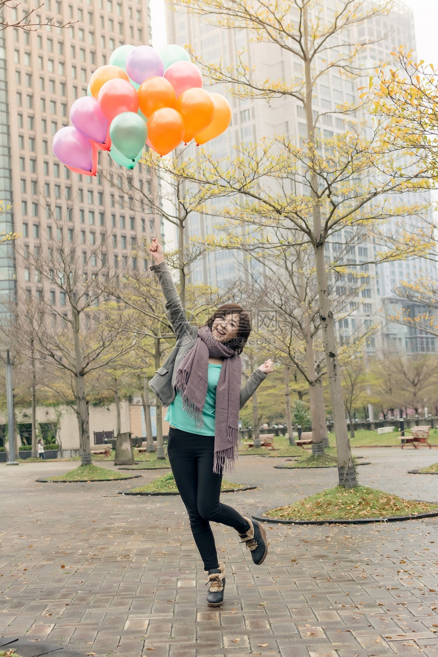 快乐笑笑的亚洲女人拿着气球魅力女性乐趣公园快乐微笑女士图片