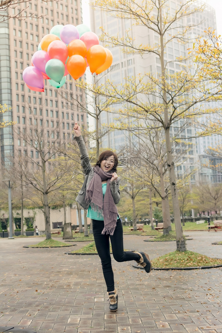 快乐笑笑的亚洲女人拿着气球快乐乐趣公园女士魅力女性微笑图片