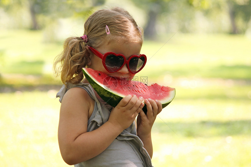 有太阳眼镜的小女孩 吃西瓜西瓜孩子食物女性微笑水果甜点童年公园青年图片