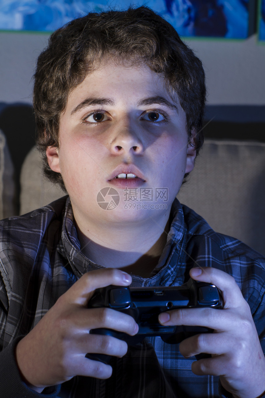 在家里玩电脑游戏的男孩儿 拿着拐杖享受视频青春期技术房间微笑电脑软垫游戏青少年图片