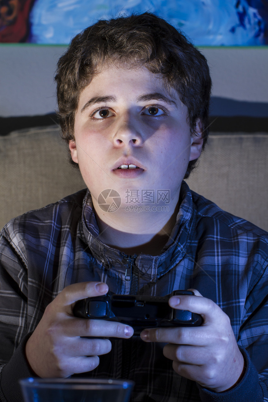 在家里玩电脑游戏的男孩儿 拿着拐杖电脑青年安慰童年技术娱乐控制青少年男生微笑图片
