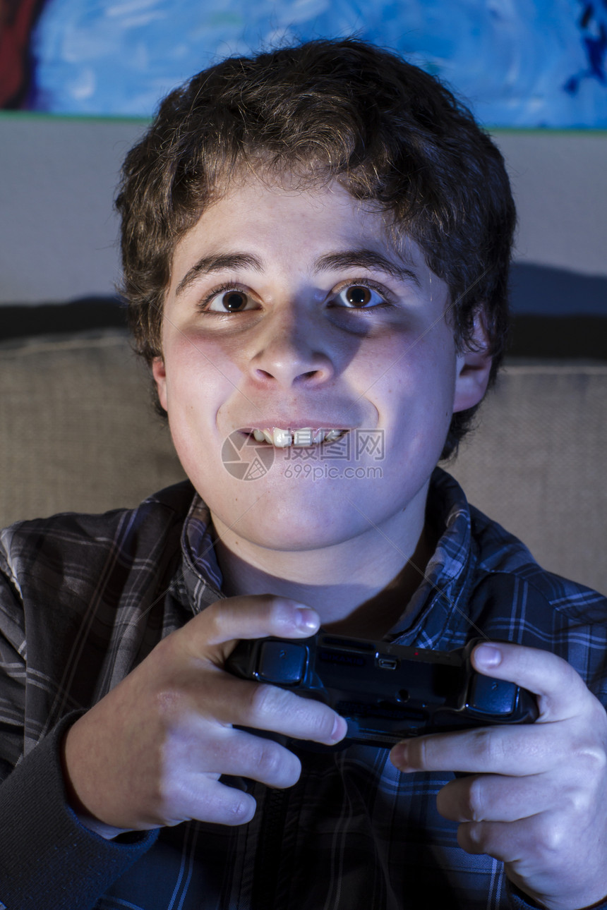 青少年 有玩棍子的男孩在家玩电脑游戏控制器沙发喜悦孩子软垫兄弟技术电脑乐趣青年图片