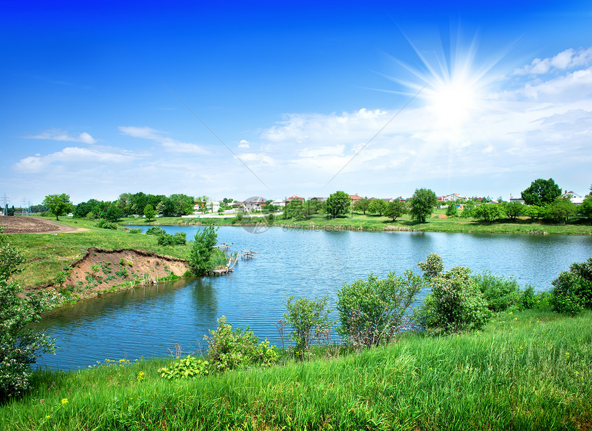 太阳在河上照耀生长支撑风光蓝色牧场田园池塘季节爬坡道反射图片