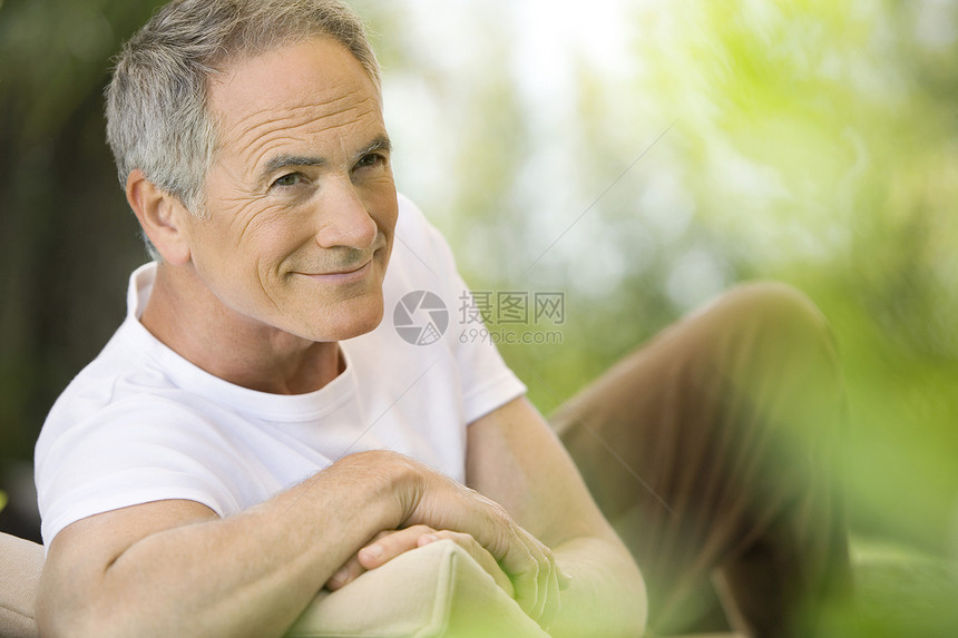 中年人靠在花园的甲板椅子上时间头肩一人成年人空闲男人家具服装休闲男士图片