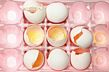 粉红泡沫塑料纸盒中的碎蛋壳背景图片