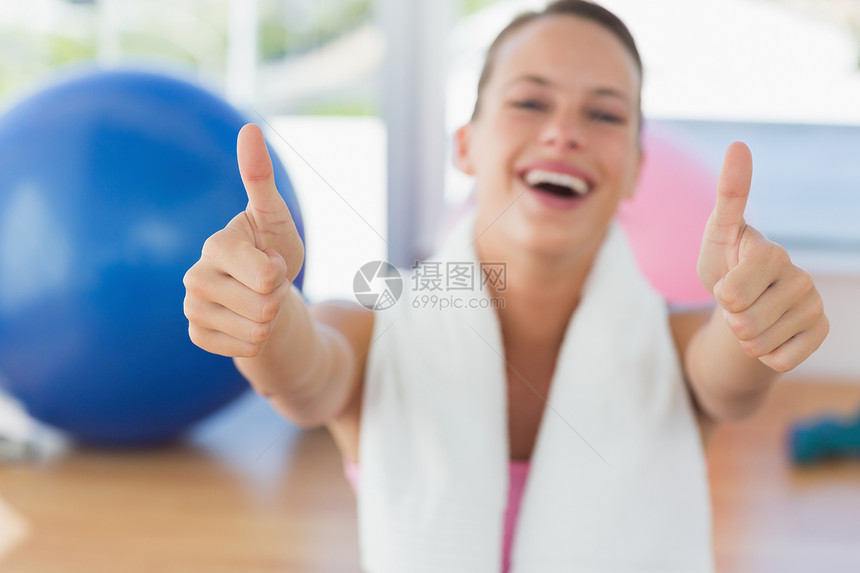 健身房有毛巾穿大拇指的女人护理培训班娱乐健身室女士手势女性闲暇健身头发图片
