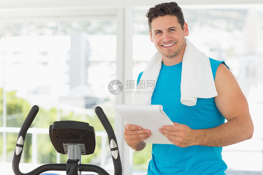 在健身房用剪贴板打微笑教练护理培训师男人毛巾肌肉男性调子运动员讲师蓝色图片