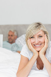 快乐的女人和男人在床上用笔记本电脑背景图片