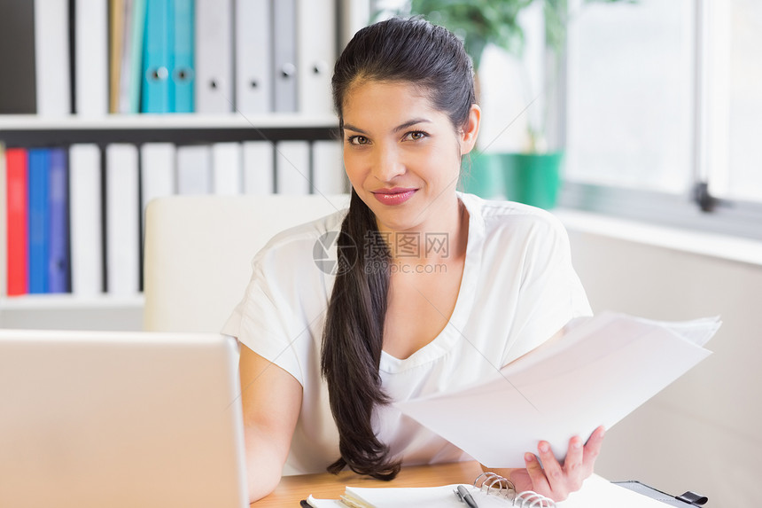 在办公服务台持有文件的女商业妇女图片