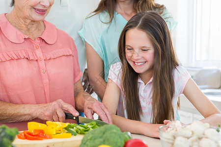 家庭用菜刀女孩看着奶奶切菜的外婆背景