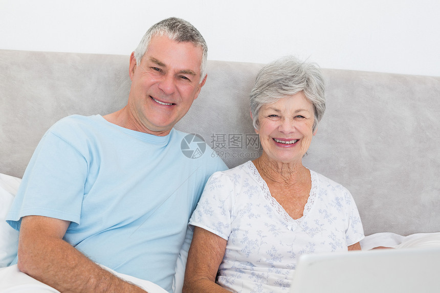 床上有膝上型电脑的老年夫妇技术退休妻子笔记本夫妻女士女性男性房子丈夫图片