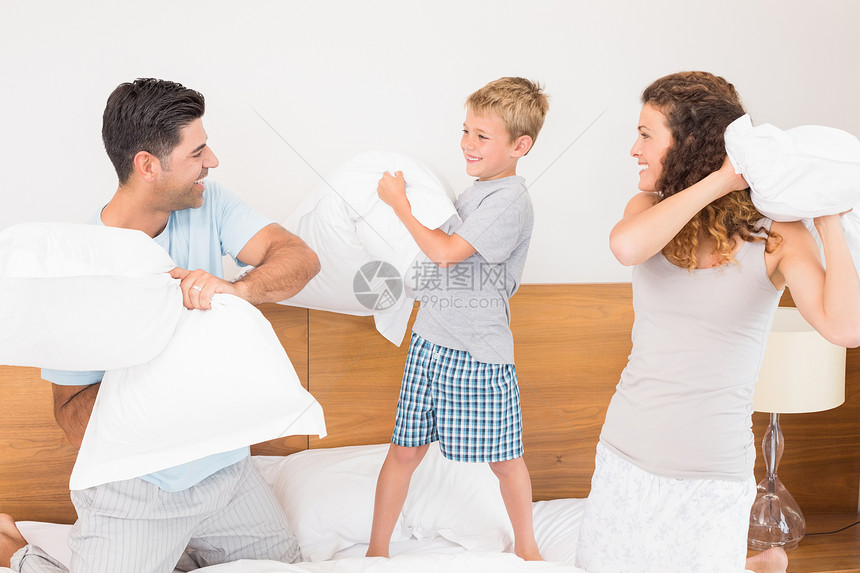 快乐的年轻家庭在枕头打架图片