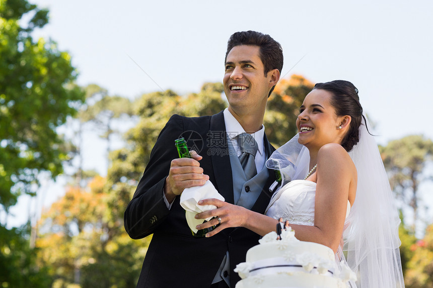 新婚夫妇 在公园喝香槟瓶图片