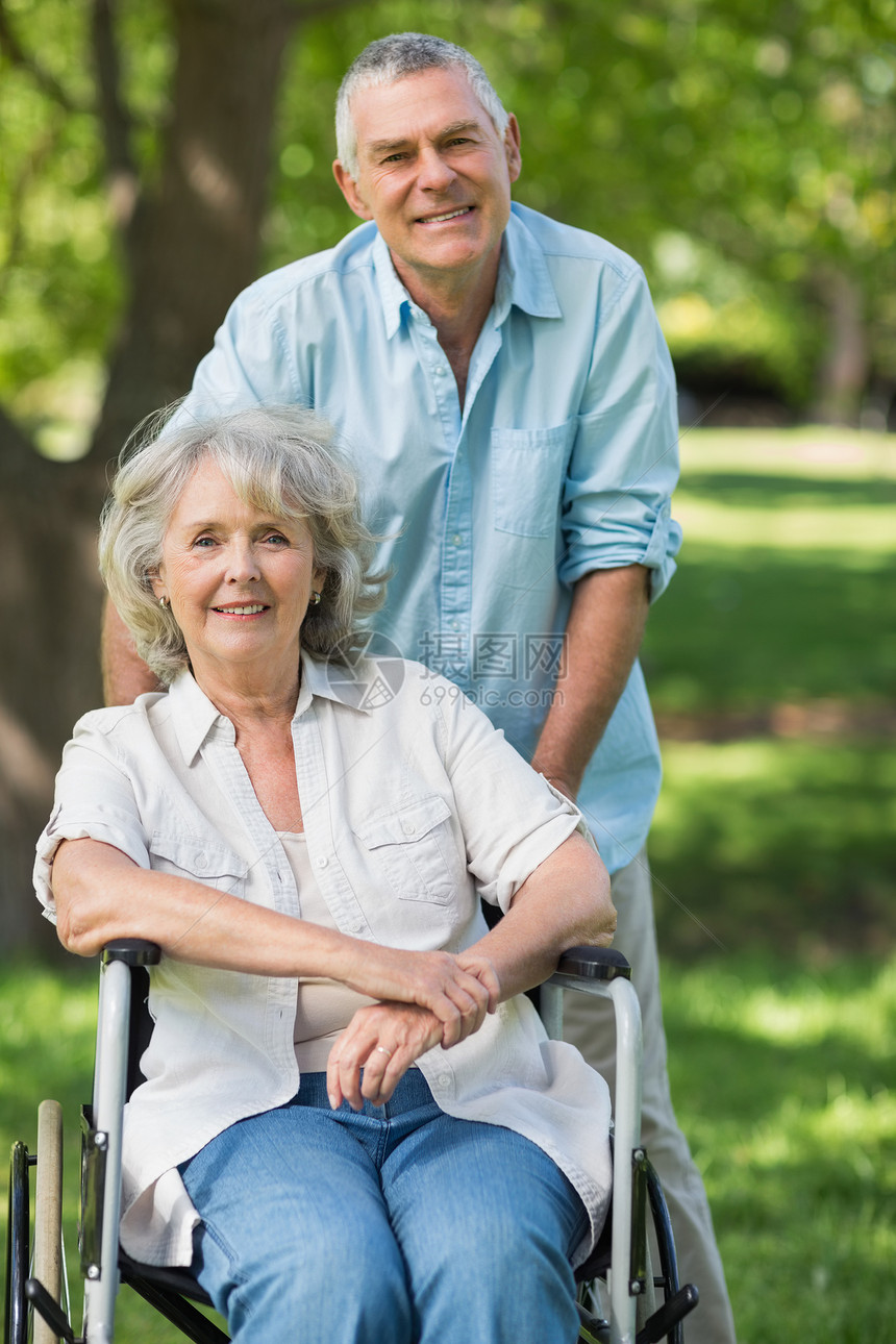 成年男子 有女性坐在公园轮椅上病人退休辅助截瘫头发女士老年残疾人疾病夫妻图片