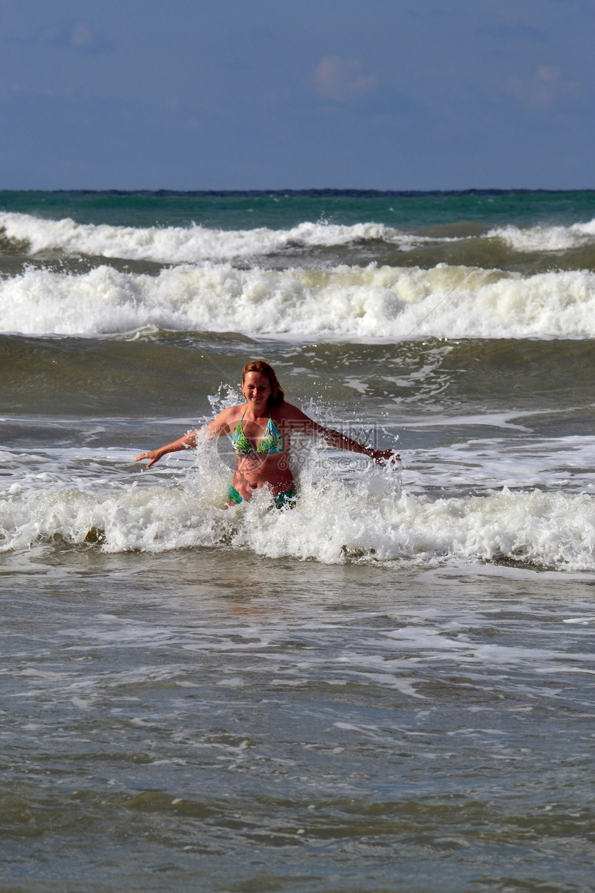 女人在海中对抗大浪飞溅波浪风暴女孩沐浴者图片