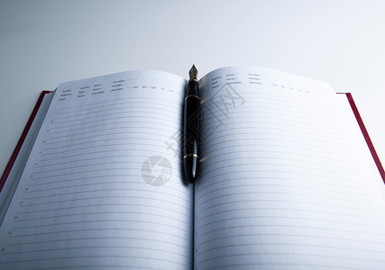 带有喷泉笔8的日记页数画板墨水钱包钢笔笔记本白色背景图片