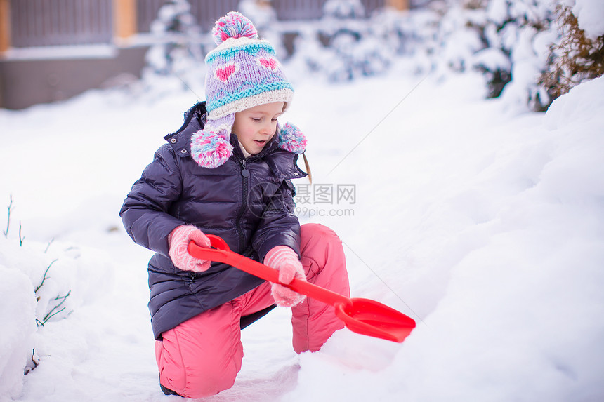 小女孩在花园里玩红铲子的小姑娘手套童年季节公园幸福闲暇婴儿快乐微笑雪堆图片