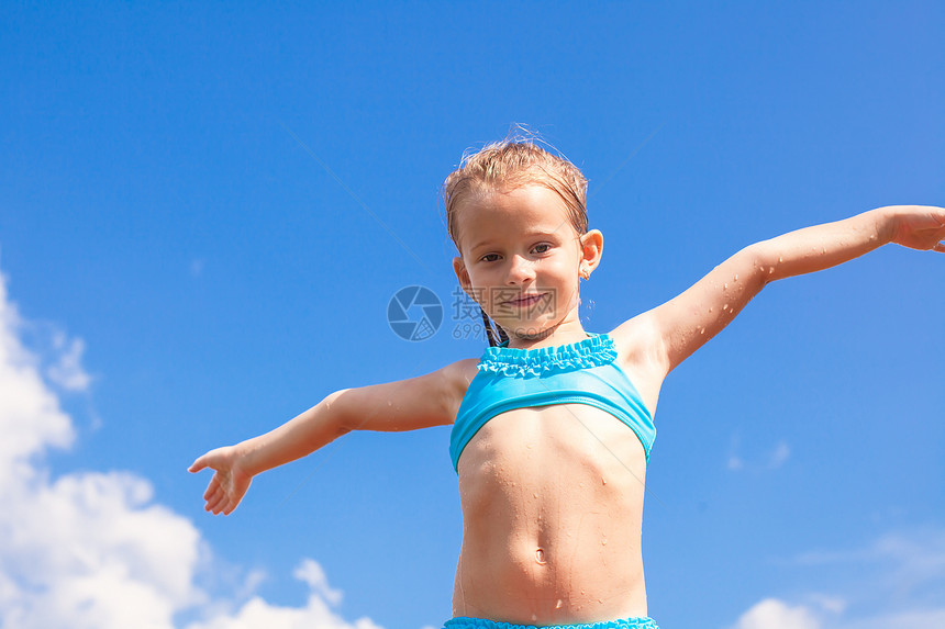 可爱的小女孩 在蓝天上张开双臂背景乐趣闲暇童年老大自由女孩女性女儿游泳者农村图片