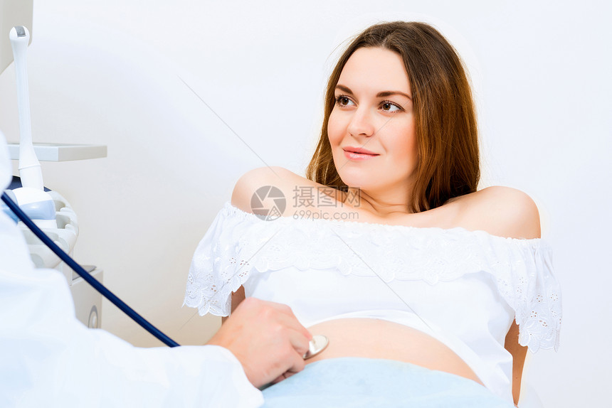 接受医生诊治的怀孕妇女女士微笑待产病人诊所腹部顾问咨询肩膀家庭图片