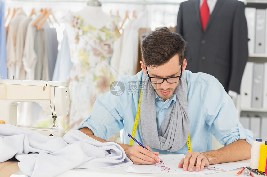 时装设计师在设计自己的设计工作铅笔绘画卷尺商业男性缝纫机眼镜男人工艺图片