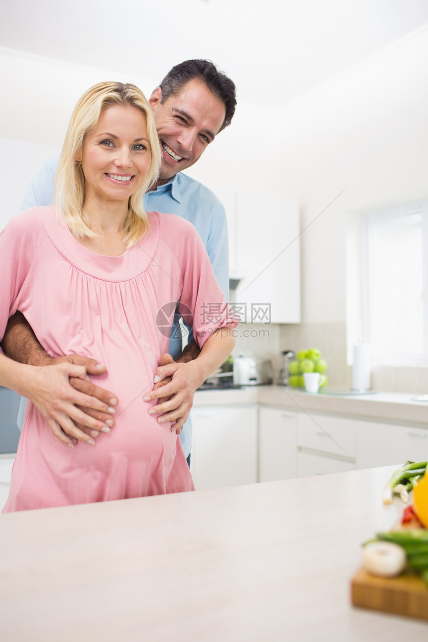 一位在厨房有怀孕母亲的快乐父亲的肖像孕产女性肚子待产夫妻生活男人腹部微笑公寓图片