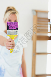 在新房子里拿着油漆刷子的模糊女人刷子梯子油漆头发女性浅色金发女郎金发装修公寓背景图片