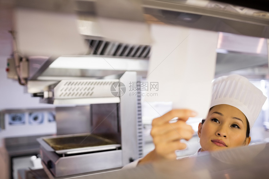 女厨师在厨房通过烹饪核对表柜台女士帽子检查职员工作清单女性商业餐厅图片