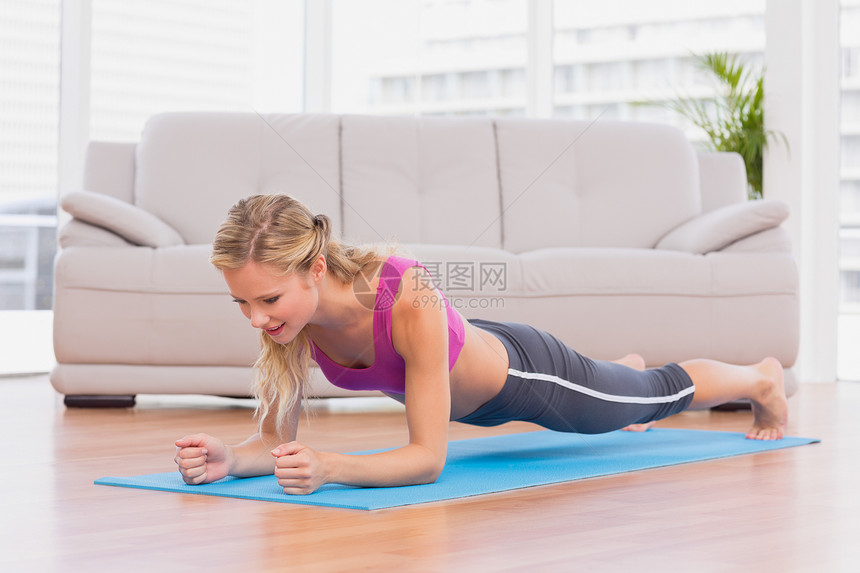 金发金发美女 坐在运动垫上的木板位置图片