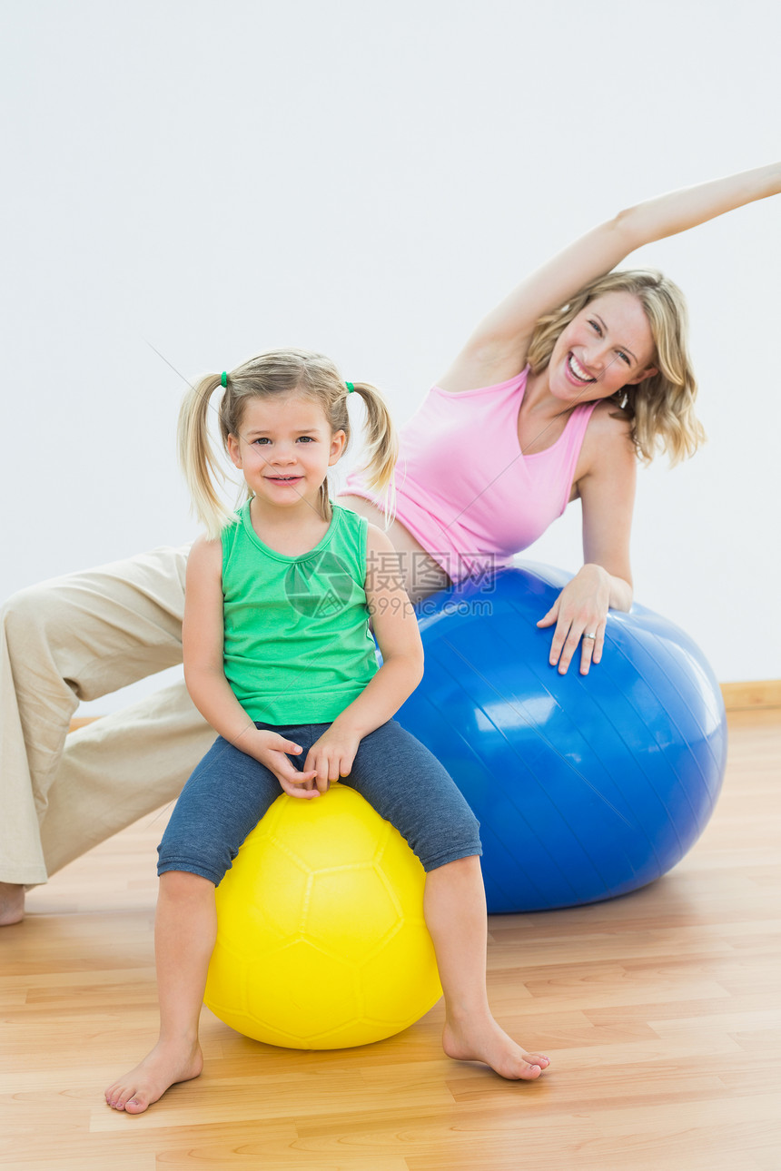 快乐的孕妇与年轻女儿一起在健身舞会上锻炼图片