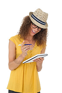 以笔记本写作的快乐年轻女子女性帽子女士眼镜微笑笑声记事本背景图片