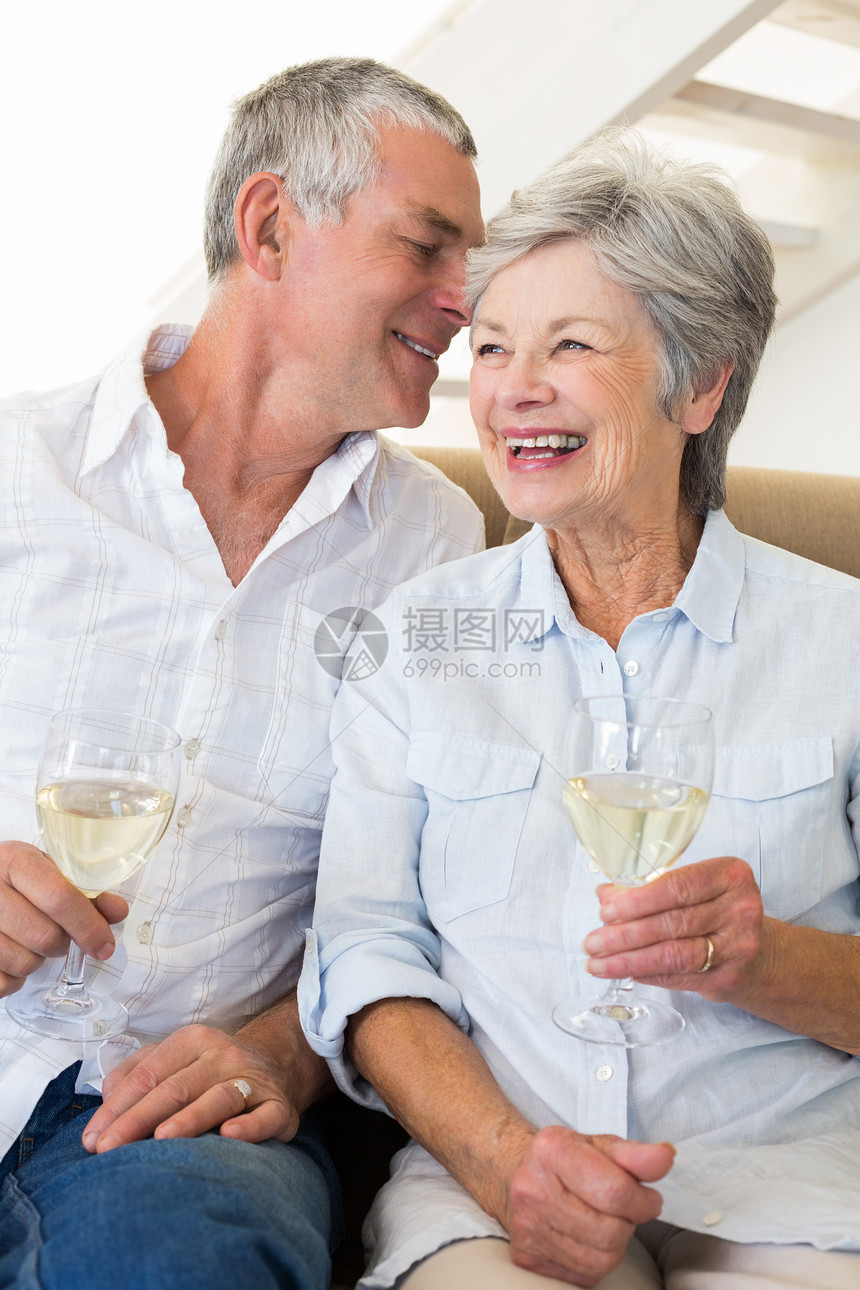 坐在沙发上喝白酒的年长夫妇闲暇房子成人家庭流金退休男性客厅男人微笑图片