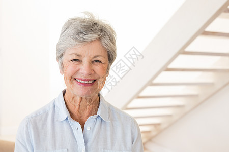 退休的女人对着镜头微笑背景图片